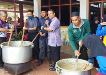 MOHD. Amirruddin Arzami, (tiga, kiri) mengacau bubur Asyura bersama pelajar dan kakitangan sekolah ketika Program Mengacau Bubur Asyura di Sekolah Rendah Tunku Putera (SKTP), Baling Kedah baru-baru ini.