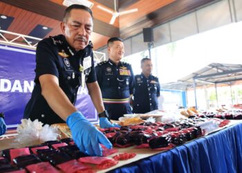 MUHAMAD Zaki Harun (kiri) menunjukkan dadah yang dirampas semasa sidang media di Ibu Pejabat Polis Kontinjen Kelantan (IPK) Kota Bharu,Kelantan.-UTUSAN/KAMARUL BISMI KAMARUZMAN