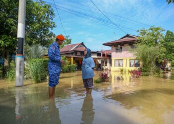 SAIFUDDIN Abdullah (kiri) bertemu penduduk yang kediaman mereka dinaiki air ketika meninjau kawasan yang dilanda banjir di Kampung Alor Madi, Alor Setar. - UTUSAN/ SHAHIR NOORDIN