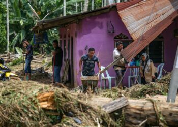 PENDUDUK mula mengemas rumah mereka yang dimasuki air akibat banjir setelah cuaca mulai baik di Kampung Iboi, Kupang, Baling. - UTUSAN/SHAHIR NOORDIN