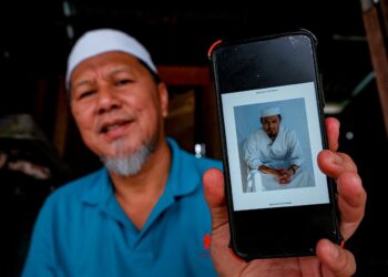 NAJIB Lep menunjukkan gambar terkini Nazir Lep ketika ditemui di Kampung Jeram Masjid, Muar, Johor. - UTUSAN/SYAFEEQ AHMAD