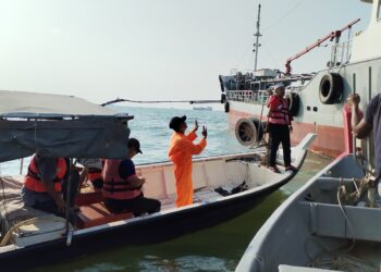 AZIZ Jaapar (dua dari kanan) sedang memperkatakan sesuatu kepada pekerja sebuah kapal yang menyebabkan jaring pukat hanyut tersangkut berhampiran Pulau Upeh, Melaka. - UTUSAN/AMRAN MULUP