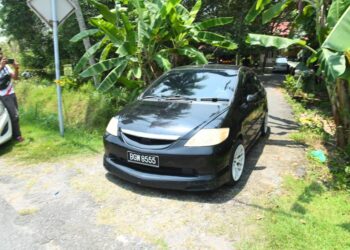SUSPEK menaiki kereta berwarna hitam dibawa keluar dari lokasi kejadian kes bunuh isterinya di sebuah rumah di Kampung Padang Nyu, Arau, Perlis hari ini.-UTUSAN/IZLIZAN OTHM