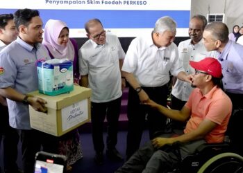 AHMAD ZAHID Hamidi (tiga dari kanan) menyampaikan skim faedah Perkeso kepada seorang penerima pada Karnival Kerjaya MyFuture Jobs bersama Hawa Malaysia di Dataran Ilmu Felda Chemomoi, Pelangai di Bentong, Pahang.