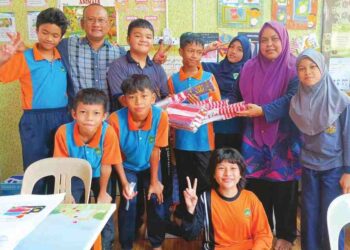 KHAIRUL NIZAM Abu Dahari (belakang, dua dari kiri) menyampaikan sumbangan Jalur Gemilang kepada guru sambil disaksikan oleh pelajar Pendidikan Khas di Sekolah Kebangsaan Bukit Sekilau, Kuantan baru-baru ini. – HARIS FADILAH AHMAD