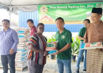 CHUAH Chong Choon  (dua dari kanan) menyerahkan sumbangan beras kepada penduduk sempena pembukaan syarikat membeli kelapa sawit, Maju Matang Trading di Matang, Taiping hari ini. - UTUSAN/WAT KAMAL ABAS