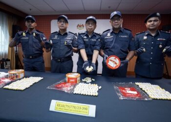 WONG Pun Sian (tengah) menunjukkan dadah jenis kokain dalam tin biskut di KLIA Terminal 1. - UTUSAN/FAISOL MUSTAFA