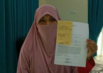 NOR Azlina Mohamad Yasin menunjukkan laporan polis yang dibuat selepas anak keduanya menjadi mangsa penderaan emosi oleh pihak sebuah sekolah di Marang. - UTUSAN/TENGKU DANISH BAHRI TENGKU YUSOFF