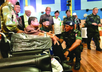 SHEIK Azahar Sheik Omar (duduk kanan) beramah mesra dengan pesara yang menerima bantuan kerusi roda di Markas Batalion 8 PGA Pengkalan Chepa, Kota Bharu, Kelantan, semalam.  - UTUSAN/ ROSLIZA MOHAMED