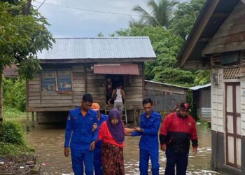 ANGGOTA Angkatan Pertahanan Awam Malaysia (APM) membantu memindahkan mangsa ke PPS SK Arau, Perlis yang mula beroperasi petang tadi. -UTUSAN/APM