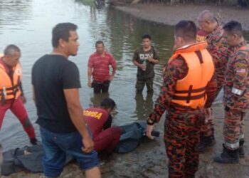 ANGGOTA bomba memeriksa mayat Tuan Muhammad Iyad Tuan Noor Marzuki yang ditemukan lemas di Sungai Ibai dekat Kampung Laut, Kuala Terengganu, petang tadi. - UTUSAN/TENGKU DANISH BAHRI TENGKU YUSOFF