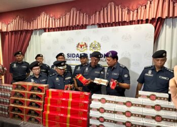 SAZALI MOHAMAD (dua dari kanan) memeriksa rampasan rokok putih dan kretek pada sidang akhbar di Menara Kastam Johor Bahru, semalam.