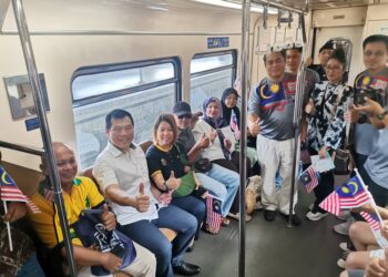 LOH Sze Yee (dua dari kiri) bergambar bersama penumpang KTM yang dalam perjalanan ke Stesen Butterworth, Pulau Pinang. - UTUSAN/ASLIZA MUSA