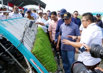 MOHAMAD Sabu (dua dari kanan) diberi penerangan mengenai benih padi yang dihasilkan di ladang kekal pengeluaran biji benih padi pada perasmian ladang tersebut di Felcra Bhd Seberang Perak di Pasir Salak hari ini. - UTUSAN/ZULFACHRI ZULKIFLI