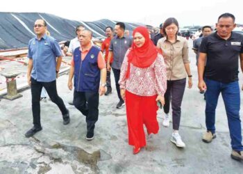 SAARANI Mohamad (tengah) melihat bumbung premis perniagaan di Ipoh Night Market yang roboh akibat ribut. – UTUSAN/MUHAMAD NAZREEN SYAH MUSTHAFA