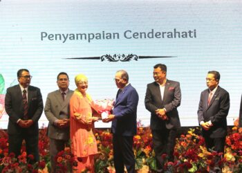 WAN ROSDY Wan Ismail (tiga dari kanan) menyampaikan cenderahati kepada Profesor Kehormat Universiti Kebangsaan Malaysia (UKM), Profesor Datuk Seri Dr. Mushrifah Idris di Swiss-Belhotel di Kuantan, Pahang. - FOTO/SHAIKH AHMAD RAZIF