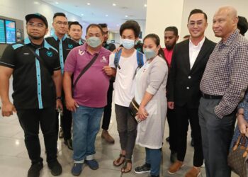 HISHAMUDDIN Hashim bersama mangsa yang dibawa pulang dari Myanmar di Terminal 2, KLIA Sepang. - UTUSAN/AMREE AHMAD