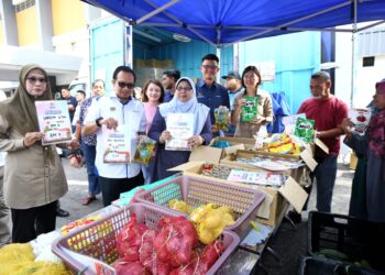 FUZIAH Salleh (tengah) menunjukkan barangan yang dijual pada Program Jualan Rahmah Bergerak (PJRB) peringkat negeri Perak di Gopeng hari ini. - UTUSAN/MUHAMAD NAZREEN SYAH MUSTHAFA