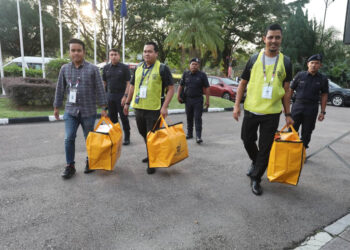 BEBERAPA petugas SPR membawa beg berisi peti undi ke pusat Penjumlahan Undi PRK Parlimen Pulai di Dewan Jubli Intan Sultan Ibrahim Johor Bahru.