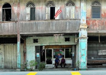 R. GNASERGARAN (kanan) bersama rakannya, S. Jagaiyah di hadapan kedai gunting mereka di pekan Kampung Kepayang dekat Gopeng. - UTUSAN/MUHAMAD NAZREEN SYAH MUSTHAFA