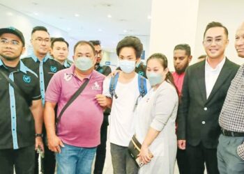 HISHAMUDDIN Hashim (kiri) bersama mangsa yang dibawa pulang dari Myanmar di Terminal 2, KLIA Sepang, kelmarin. – UTUSAN/AMREE AHMAD