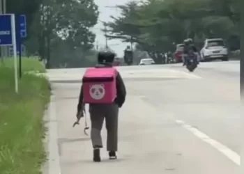 PEKERJA P-hailing tular dalam media sosial apabila sebuah video memaparkannya berjalan kaki sambil menggalas beg makanan selepas motosikalnya disita dalam operasi sekatan jalan raya kira-kira 12 tengah hari di Nilai, Negeri Sembilan, kelmarin. -GAMBAR MEDIA SOSIAL
