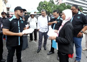 HISHAMUDDIN Hashim (kiri) menyerahkan memorandum bantahan berkaitan arahan menukar status tanah kepada  rizab Melayu kepada Nur Azlina Othman di Ipoh hari ini. - UTUSAN/MUHAMAD NAZREEN SYAH MUSTHAFA