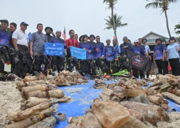 AZBI Salleh (lima dari kiri) melihat sebahagian sampah yang dikutip di dasar laut pada Program Sukarelawan PADI Aware Dive Against Debris dan aktiviti pembersihan pantai di Pasir Panjang, Pulau Perhentian, Besut, semalam.  - UTUSAN/PUTRA HAIRRY ROSLI