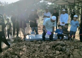 AMBOK Salingkek Abd. Fatah menyiram air mawar ke atas kubur ibunya, Indok Akok Dg. Sitakak dan adiknya, Tahallah Abd. Fatah di Tanah Perkuburan Islam Kampung Parit Kerimon, Benut, Pontian, hari ini.