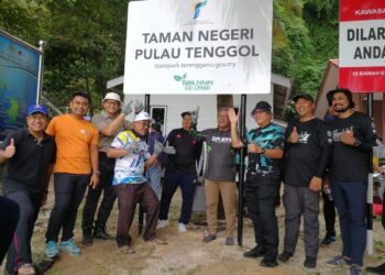 TENGKU Farok Hussin Tengku Abdul Jalil (tiga, kanan) menunjukkan papan tanda Taman Negeri Pulau Tenggol yang dipasang di Pulau Tenggol, Dungun, semalam. - UTUSAN/NIK NUR IZZATUL HAZWANI NIK ADNAN