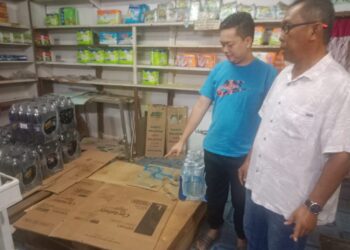 AIZAT Majid (kiri) dan Anuar Rahman  (kanan) menunjukkan tempat minyak masak peket yang kosong di kedainya di Felda Tekam Utara di Jerantut, Pahang. - FOTO/HARIS FADILAH AHMAD