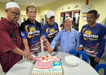 HARIS SALLEH Hamzah (tengah) bersama penduduk sedang memotong kek Hari Malaysia selepas acara penutupan bulan kemerdekaan di Felda Padang Piol di Jerantut, Pahang. - FOTO/HARIS FADILAH AHMAD