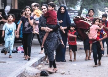 WANITA Palestin bersama anak-anak mereka menyelamatkan diri berikutan serangan udara tentera Israel di sepanjang jalan di Bandar Gaza, Palestin. – AFP