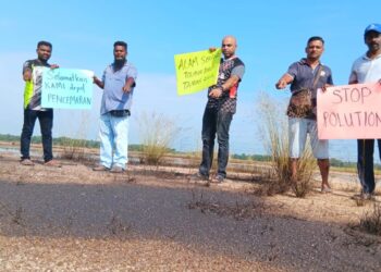 PENDUDUK mengangkat sepanduk membantah pencemaran minyak dekat sebuah tapak pembinaan kawasan industri Bukit Kapar di Klang, Selangor, semalam.