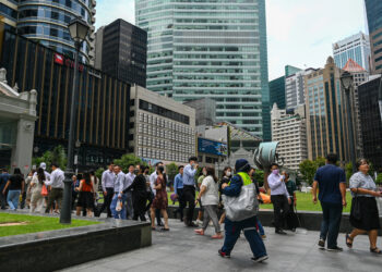 ORANG ramai berjalan di sekitar Raffles Place di Singapura.-AFP