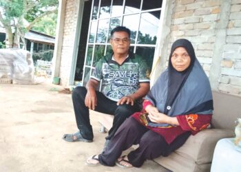 ZURIAH Md. Noor (kanan) bersama Mohd. Azli Sulaima di rumah mereka di Felda Kota Gelanggi Dua di Jerantut, Pahang. - UTUSAN/HARIS FADILAH AHMAD