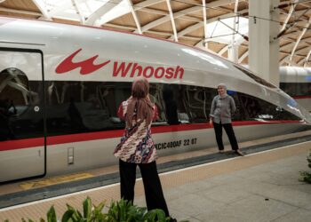 PENGUNJUNG bergambar dengan kereta api berkelajuan tinggi Whoosh di Jakarta, kelmarin. - AFP