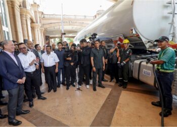 FADILLAH Yusof (kiri) mendengar penerangan daripada wakil Petronas pada Majlis Pelancaran B100 dan Persidangan ke 4 Palm Biodiesel di Putrajaya. - UTUSAN/FAISOL MUSTAFA
