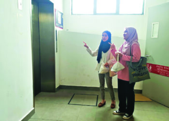 DUA pelajar menunjukkan salah satu lif yang rosak di bangunan pangsapuri yang disewa mereka di Seremban 3, Seremban.