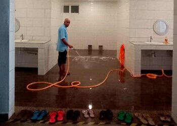 PETUGAS masjid membersihkan tandas Masjid Tuminah Hamidi di Bagan Datuk yang kotor.