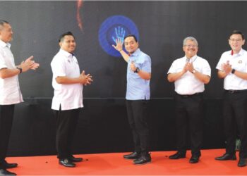 ONN HAFIZ GHAZI meletakkan tapak tangan pada skrin sebagai gimik perasmian Projek Pembesaran Lapangan Terbang Antarabangsa Senai di Kulai, semalam.