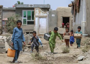BEBERAPA kanak-kanak mengambil barangan selepas rumah mereka musnah akibat banjir di Ghazni, Afghanistan pada Julai lalu. - AFP