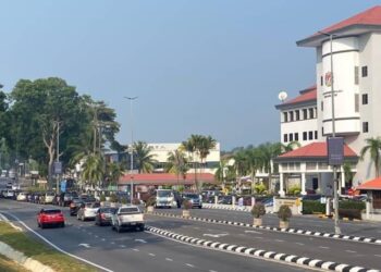 KENDERAAN berbaris panjang Jalan Kluang - Batu Pahat untuk membuat pusingan U di Taman Desa sebelum ke Wisma Persekutuan di Kluang.