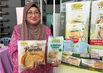 FATIHAH Anis Ibrahim menunjukkan pelbagai produk sejuk beku keluaran syarikatnya, Fatihah Frozen Food Sdn. Bhd.