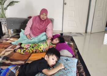 NOORAKMAR Mahmood bersama dua orang anaknya yang merupakan OKU di rumahnya di Kampung Batu, Rembau, semalam.-UTUSAN/NOR AINNA HAMZAH.