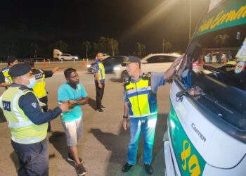 ADENAN Md Isa  (kanan) memeriksa kenderaan muatan berat dalam operasi di Plaza Tol Sungai Dua, Butterworth, Pulau Pinang malam tadi. - Pix: IQBAL HAMDAN