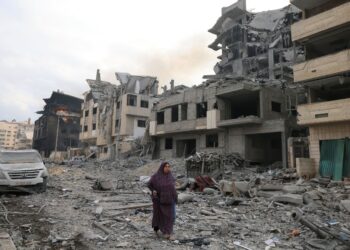 PENDUDUK Palestin berjalan melalui runtuhan bangunan yang musnah akibat serangan udara Israel di daerah al-Rimah, Gaza City. - AFP