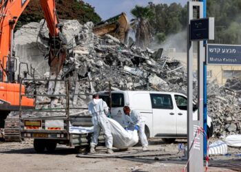 SUKARELAWAN mengangkut mayat mangsa yang maut dalam serangan di Sderot, Israel.-AFP