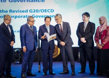 AHMAD Maslan meneliti buku Prinsip Tadbir Urus Korporat G20/OECD disaksikan  Yoshiki Takeuchi (tiga dari kanan) dan Dr. Awang Adek Hussin (dua dari kiri) dan  Abdul Wahid Omar di Kuala Lumpur, hari ini. - UTUSAN/MUHAMAD IQBAL ROSLI