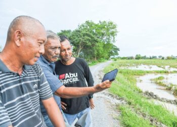 SEORANG pesawah, Zulkifli Abu Seman (kiri) bersama rakan-rakannya menonton Belanjawan 2024 yang dibentangkan Perdana Menteri, Datuk Seri Anwar Ibrahim melalui telefon pintar sementara menunggu jentera mesin padi mengumpul hasil sawah mereka di Kampung Jejawi Dalam, Arau, Perlis. – UTUSAN/IZLIZAN OTHMAN